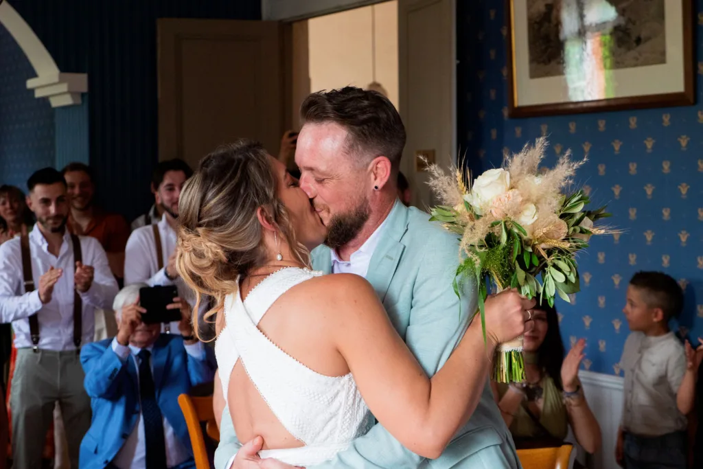 Photo des mariés s'embrassant après l'échange des voeux à la mairie d'Avignonet Lauragais (31) - Mariage d’Élodie et Julien - 2025 - Photographe à Saint-Gaudens (31) Marc Villard / VILMAGE