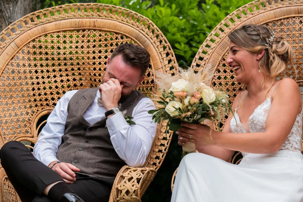 Photo des mariés éclatant de rire durant la cérémonie laïque dans le parc du château du Croisillat à Caraman (31) - Mariage d’Élodie et Julien - 2025 - Photographe à Saint-Gaudens (31) Marc Villard / VILMAGE