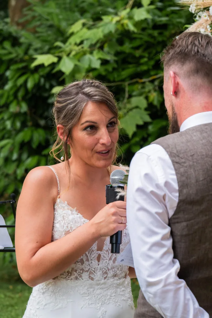 Photo gros plan de la mariée lors de l'échange des voeux à la cérémonie laïque dans le parc du château du Croisillat à Caraman (31) - Mariage d’Élodie et Julien - 2025 - Photographe à Saint-Gaudens (31) Marc Villard / VILMAGE