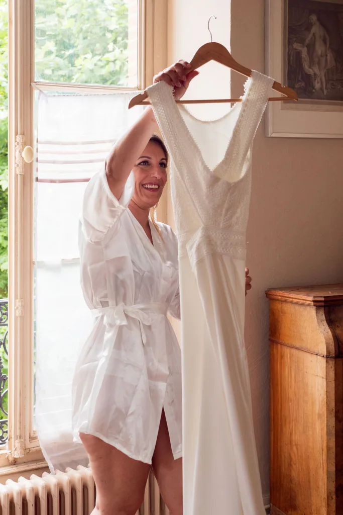 Photo de la mariée détachant sa robe de mariée dans le château du Croisillat à Camaran (31) - Mariage d’Élodie et Julien - 2025 - Photographe à Saint-Gaudens (31) Marc Villard / VILMAGE