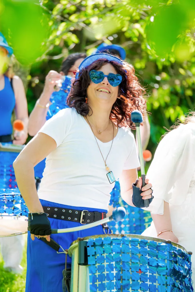 Photo d'une joueuse de batucada pour l'arrivée de la mariée à la cérémonie laïque dans le domaine de la Grange Marcaoue à Bézéril (32 - Gers) - Mariage d'Emma et Mickaël - 2025 - Photographe à Saint-Gaudens (31) Marc Villard / VILMAGE