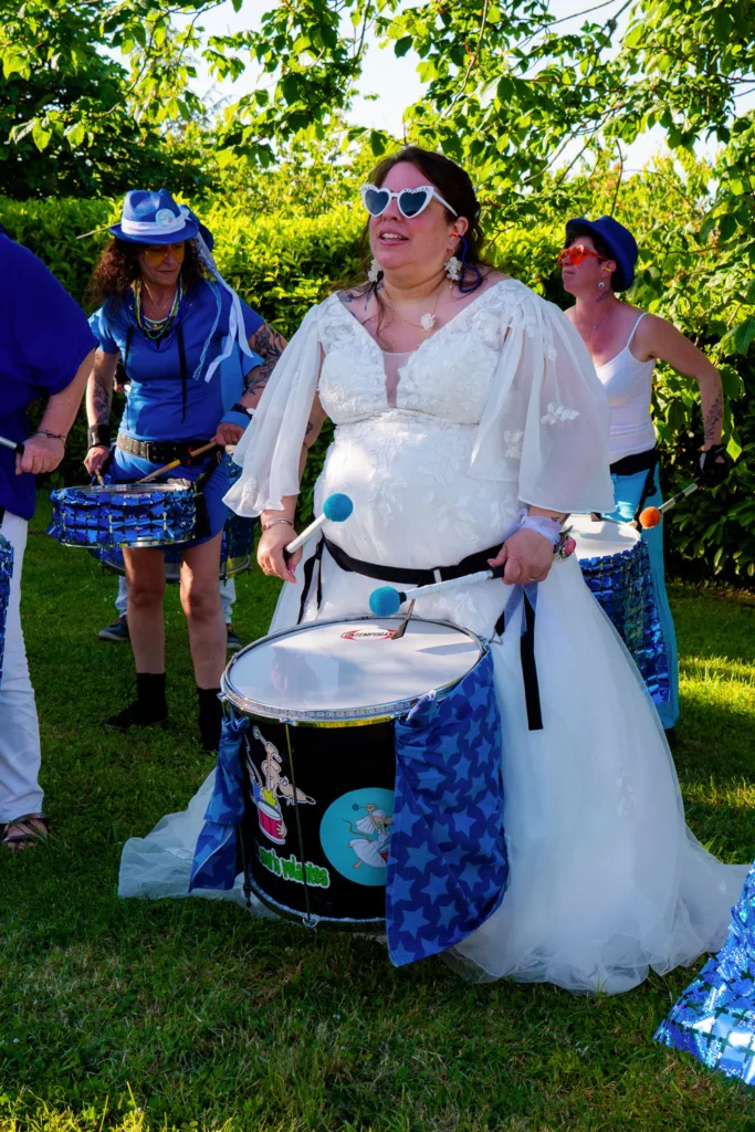 Photo de la mariée jouant de la batucada à la Grange Marcaoue à Bézéril (32 - Gers) - Mariage d'Emma et Mickaël - 2025 - Photographe à Saint-Gaudens (31) Marc Villard / VILMAGE