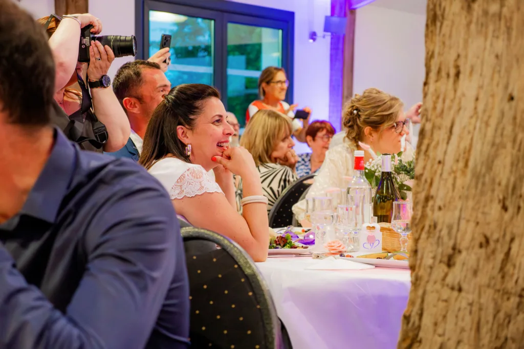 Photo des invités regardant une animation musicale et théâtrale lors de la soirée mariage d'Emma et Mickaël à la Grange Marcaoue (Bézéril -Gers) - 2025 - Photographe à Saint-Gaudens (31) Marc Villard / VILMAGE