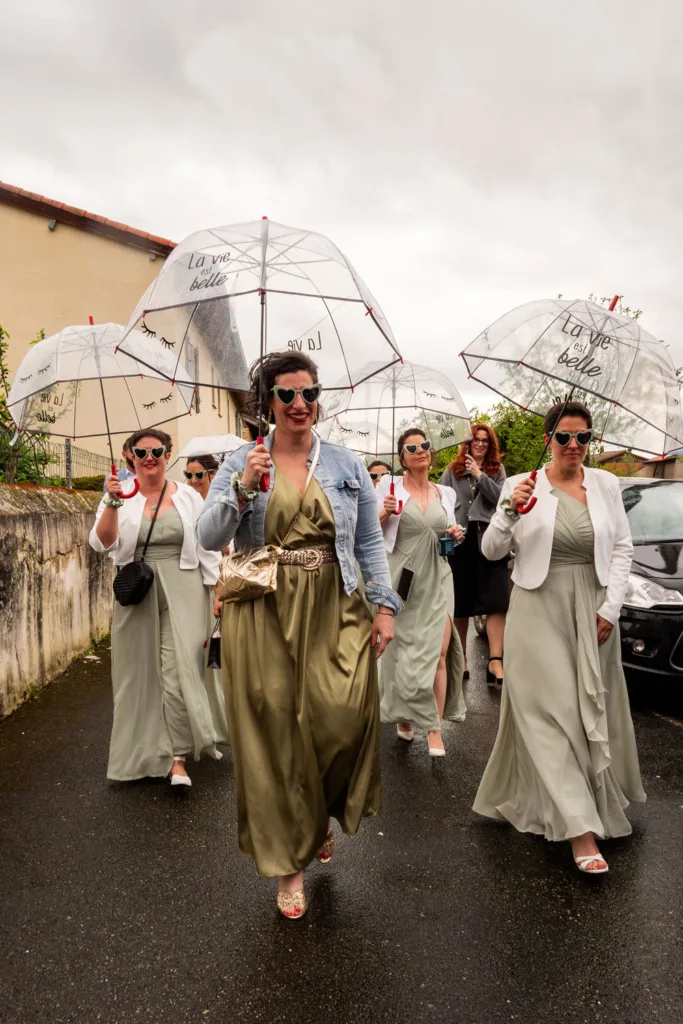 Photo des témoins de la mariée sous la pluie, sur le chemin de la mairie de Beauchalot - Mariage d'Isabelle et Jérôme - 2025 - Photographe à Saint-Gaudens (31) Marc Villard / VILMAGE